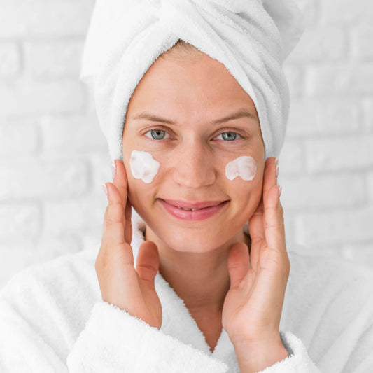 Mujer feliz aplicándose su rutina facial