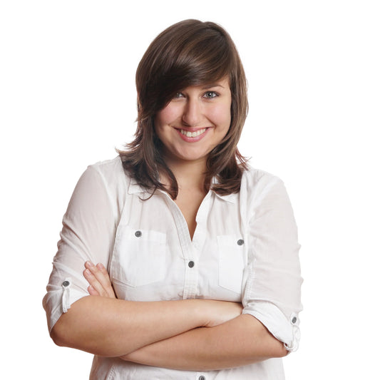 Mujer con los brazos cruzados de pie mirando al frente sonriendo